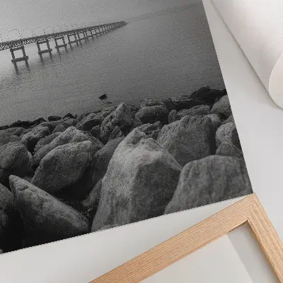 Sieninis plakatas ramus peizažas su tiltu, uolėtu paplūdimiu ir pilku dangumi