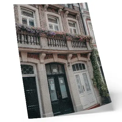 Plakatas gėlės balkone prie plytų fasado klasikiniu stiliumi