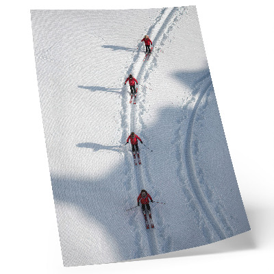 Plakatas svetainei Slidininkai sniege vilki raudonomis striukėmis