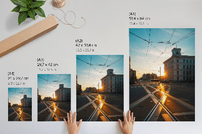 Plakatas Besileidžianti saulė virš miesto su architektūra