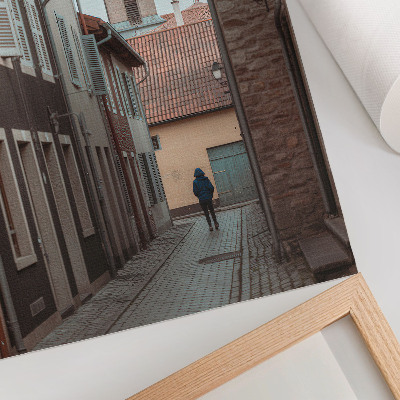 Plakatas Siaura gatvelė, daugiabučiai, bokštas, mėlynas paltas