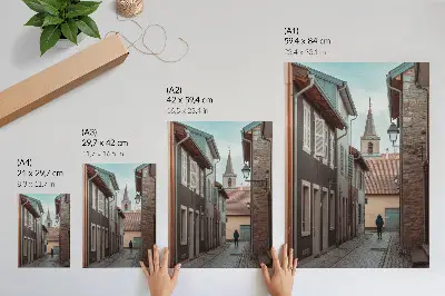 Plakatas siaura gatvelė su daugiabučiais, bokštu ir mėlynu paltu