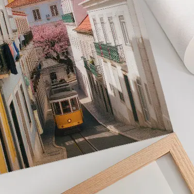Plakatas gatvė su tramvajumi, pasteliniais daugiabučiais ir gėlėmis