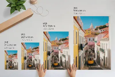 Plakatas gatvė su tramvajumi, pasteliniais daugiabučiais ir gėlėmis