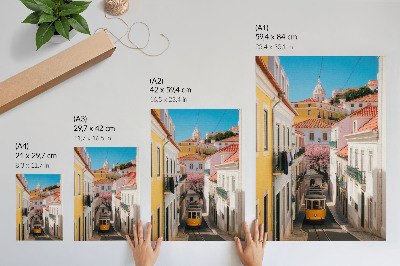 Plakatas Gatvė su tramvajumi, pastelinių spalvų daugiabučiais, gėlėmis