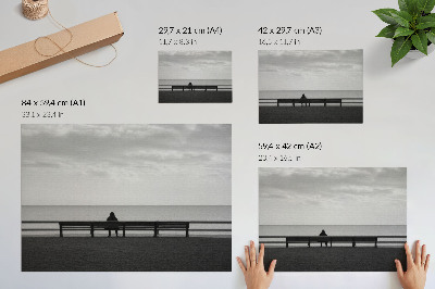 Plakatas ant drobės Žmogus ant suoliuko prie jūros pilka harmonija