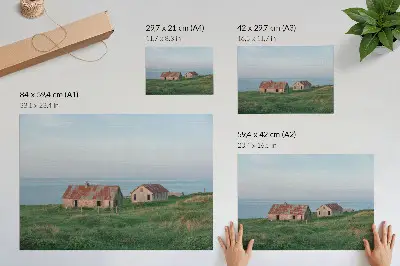 Plakatas kaimiški pastatai, žalios pievos ir jūra