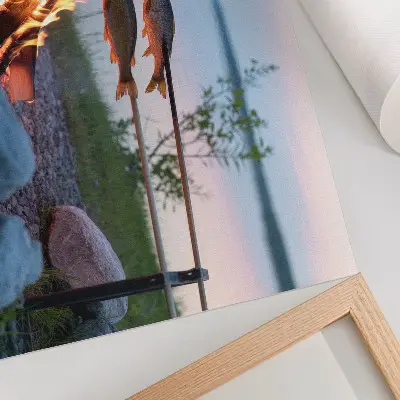 Plakatas ant drobės laužas prie ežero su besikepančiomis žuvimis