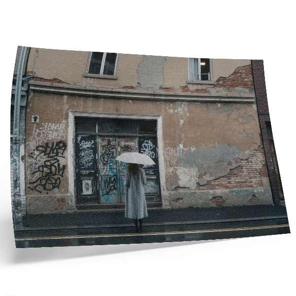 Plakatas ant drobės Žmogus su skėčiu priešais sieną, pilną grafičių