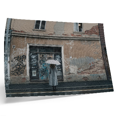 Plakatas ant drobės Žmogus su skėčiu priešais sieną, pilną grafičių