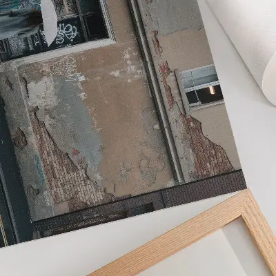Plakatas ant drobės žmogus su skėčiu prieš grafičiais išpieštą sieną