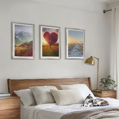 3 paveikslų rinkinys su rėmais, vaizduojantis peizažą su kalnais, medžiu, širdimi ir prieplauka