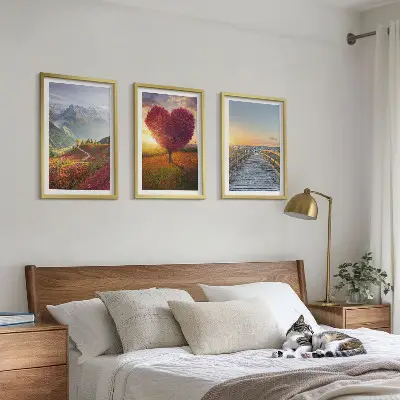 3 paveikslų rinkinys su rėmais, vaizduojantis peizažą su kalnais, medžiu, širdimi ir prieplauka